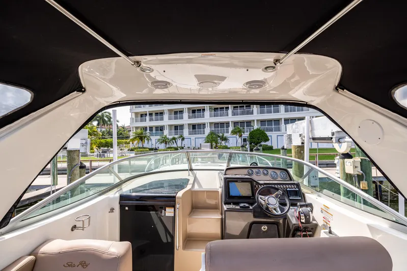  Yacht Photos Pics 2016 Sea Ray 310 Sundancer cockpit with modern controls, docked near waterfront buildings.