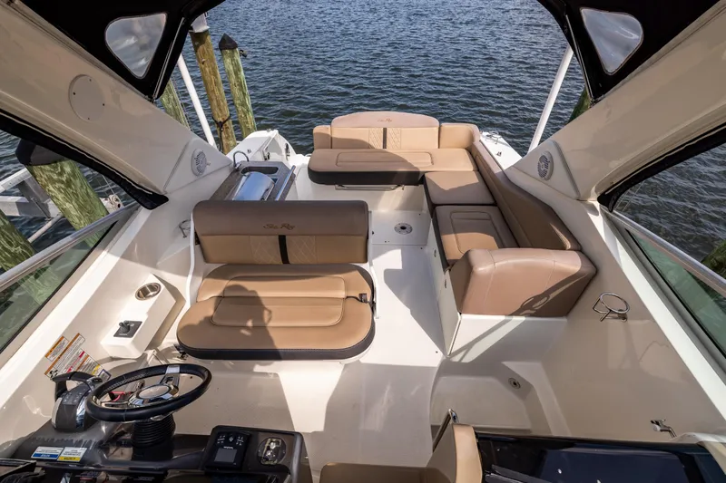  Yacht Photos Pics 2016 Sea Ray 310 Sundancer boat interior with tan seating and steering wheel, docked by water.