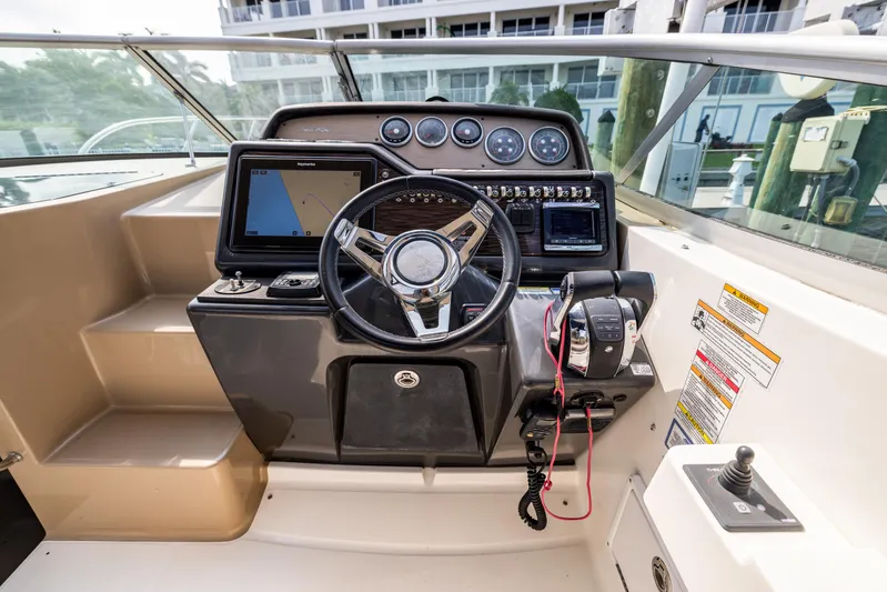  Yacht Photos Pics Cockpit of 2016 Sea Ray 310 Sundancer with steering wheel and navigation controls.