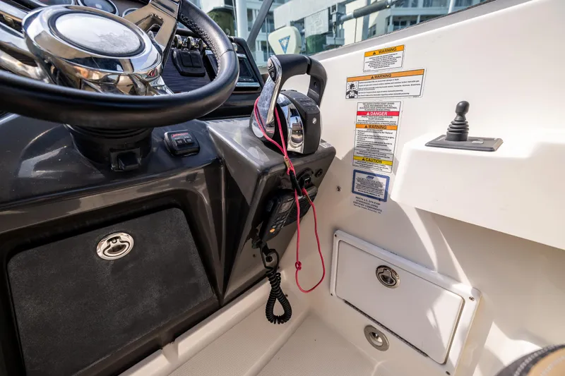  Yacht Photos Pics 2016 Sea Ray 310 Sundancer helm with steering wheel, throttle controls, and safety warnings.