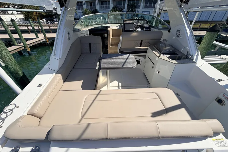 Yacht Photos Pics 2016 Sea Ray Sundancer 310 interior with beige seating and compact kitchenette.