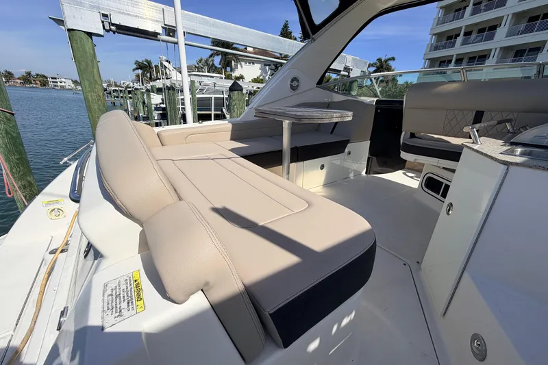  Yacht Photos Pics 2016 Sea Ray Sundancer 310 interior with beige seating and table, docked by waterfront.