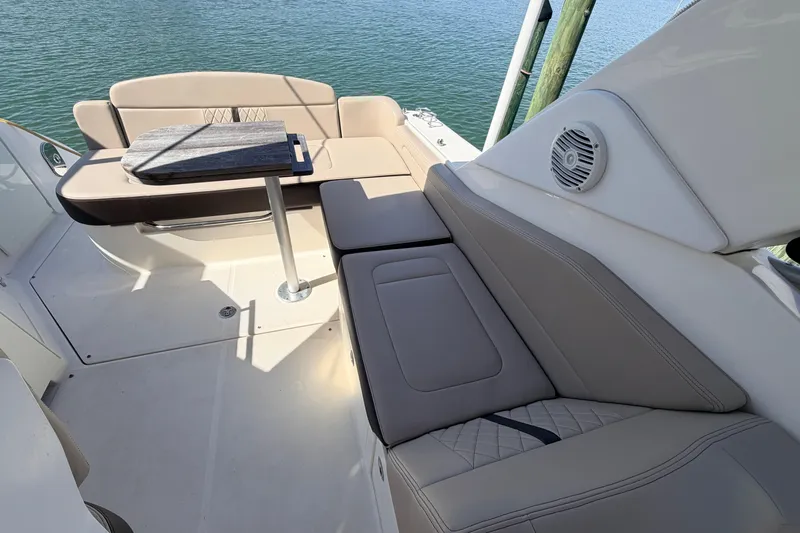  Yacht Photos Pics 2016 Sea Ray Sundancer 310 boat interior with cushioned seating and table by the water.
