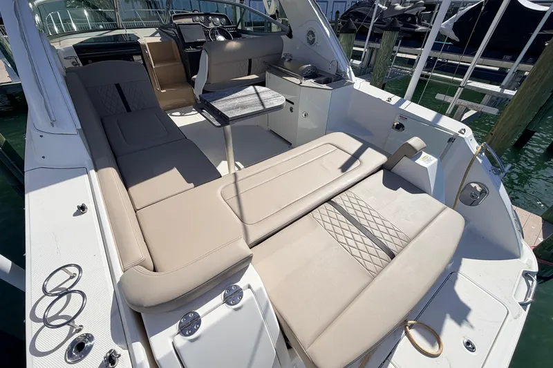  Yacht Photos Pics 2016 Sea Ray Sundancer 310 interior with beige seating and table, docked at marina.