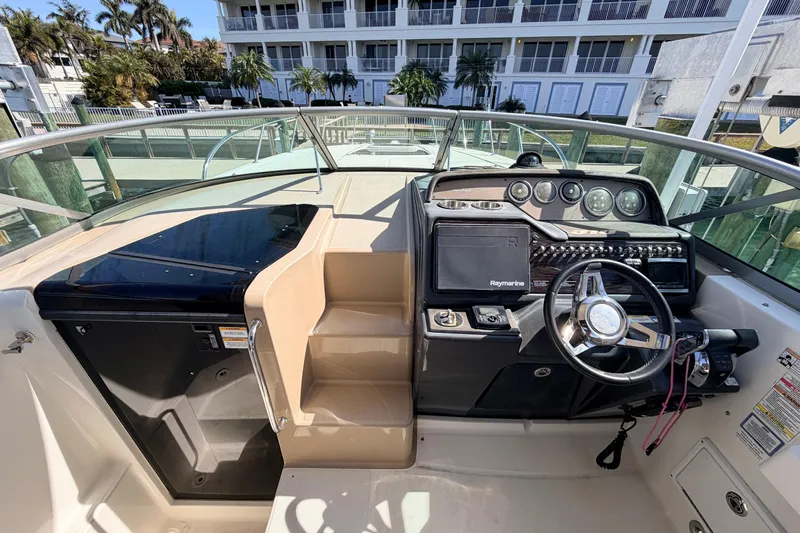  Yacht Photos Pics 2016 Sea Ray Sundancer 310 helm with modern controls and steering wheel, docked near luxury buildings.