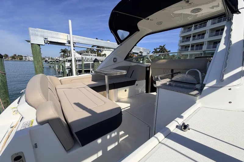  Yacht Photos Pics 2016 Sea Ray Sundancer 310 boat interior with seating and kitchenette, docked by waterfront.