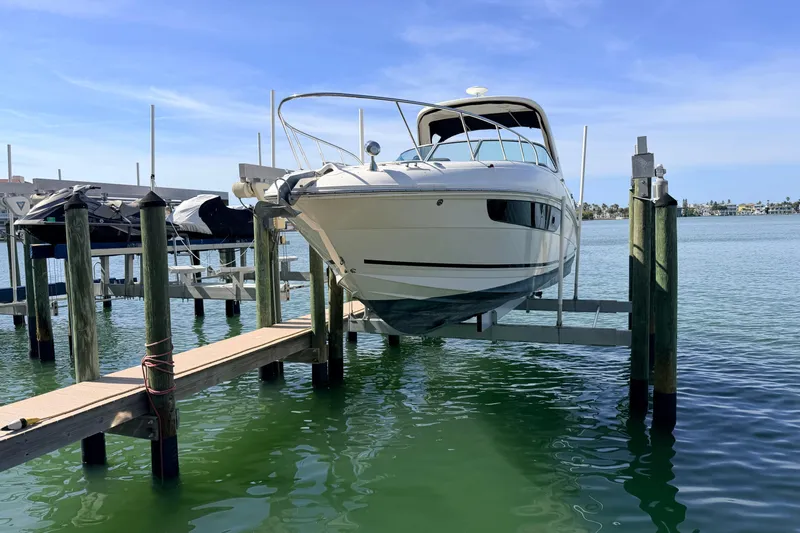  Yacht Photos Pics 2016 Sea Ray Sundancer 310 boat docked on a lift over clear water.