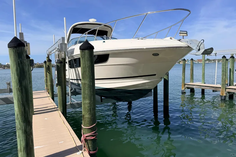  Yacht Photos Pics 2016 Sea Ray Sundancer 310 boat docked on a lift over clear water.