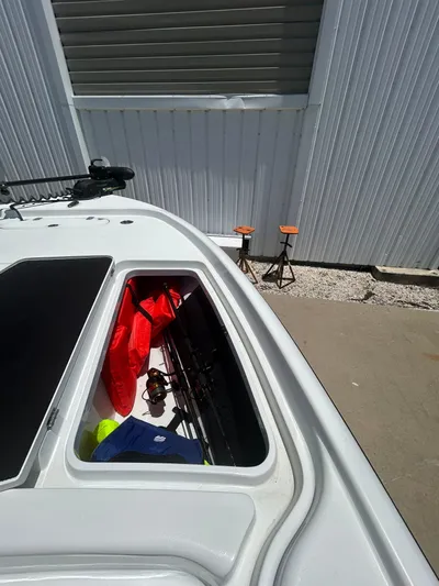  Yacht Photos Pics 2021 Yellowfin 24 Bay CE boat storage compartment with fishing gear and life jackets.