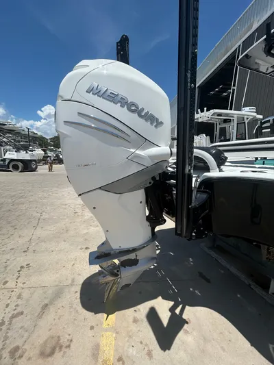  Yacht Photos Pics 2021 Yellowfin 24 Bay CE with Mercury outboard engine in a marina setting.