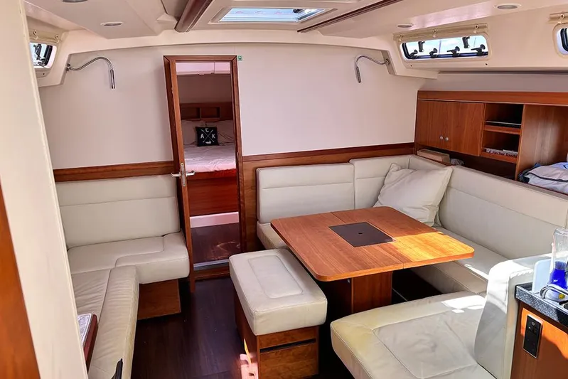Animal Spirits Yacht Photos Pics Interior of 2014 Hanse 445 yacht with cozy seating and wooden table.