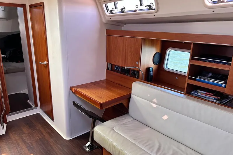 Animal Spirits Yacht Photos Pics Interior of 2014 Hanse 445 yacht with wooden desk, shelves, and seating area.