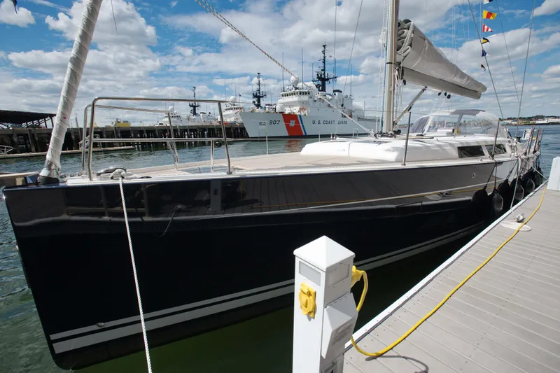 Animal Spirits Yacht Photos Pics 2014 Hanse Yachts 445 sailboat docked at marina with coast guard ship in background.