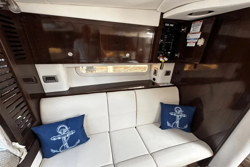 Parce Yacht Photos Pics Interior of 2016 Sea Ray 310 Sundancer with white seating and nautical-themed pillows.