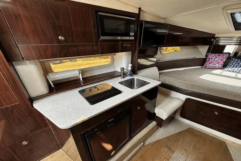 Parce Yacht Photos Pics 2016 Sea Ray 310 Sundancer interior with kitchenette, sink, and cozy seating area.