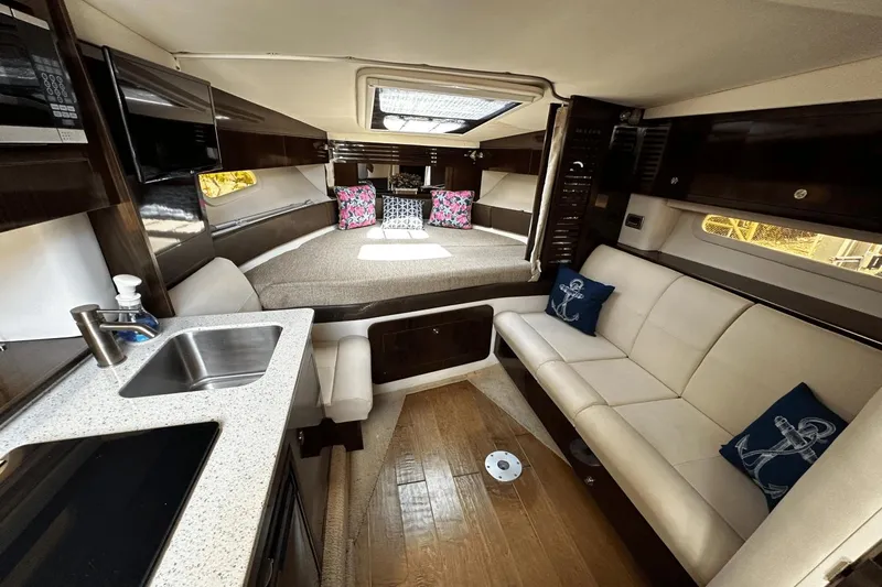 Parce Yacht Photos Pics Luxurious interior of 2016 Sea Ray 310 Sundancer with kitchenette and seating area.