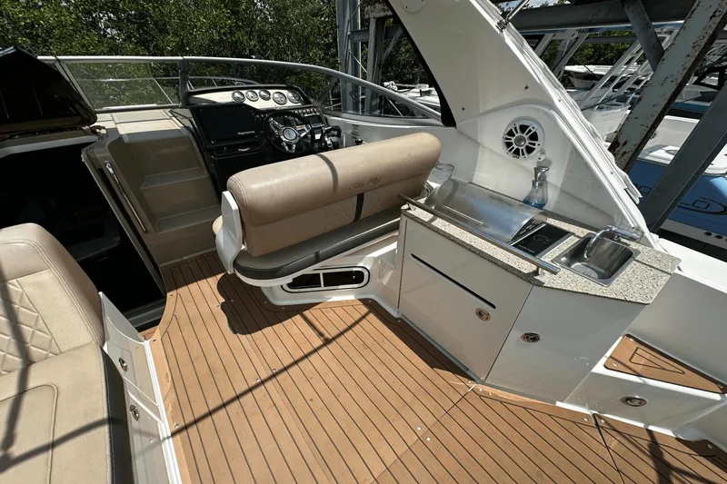 Parce Yacht Photos Pics 2016 Sea Ray 310 Sundancer cockpit with seating, helm, and kitchenette area.
