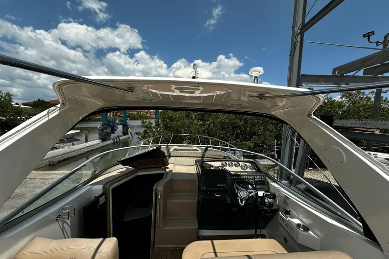 Parce Yacht Photos Pics 2016 Sea Ray 310 Sundancer cockpit with helm, docked under clear blue sky.