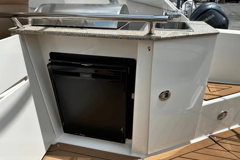 Parce Yacht Photos Pics 2016 Sea Ray 310 Sundancer boat kitchenette with sink and mini fridge.