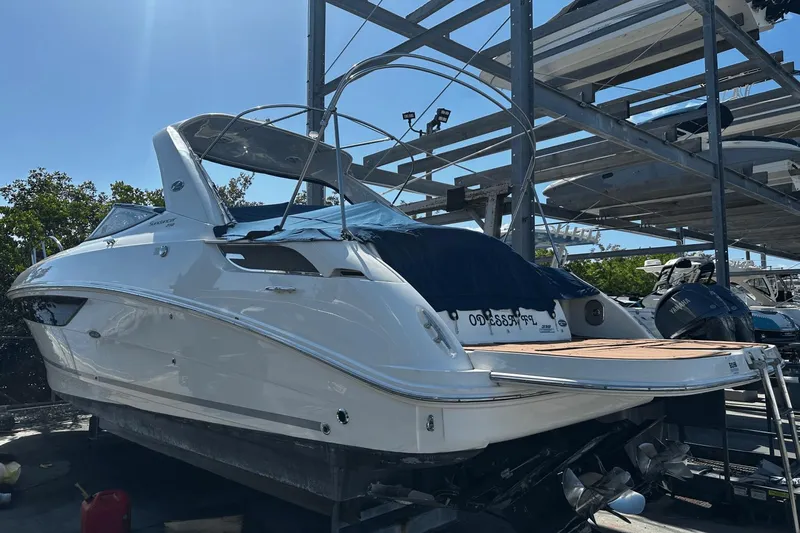 Parce Yacht Photos Pics 2016 Sea Ray 310 Sundancer boat docked in a marina under a clear blue sky.