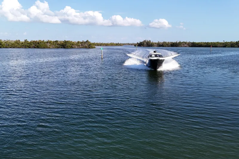  Yacht Photos Pics 2026 Solara S-250 Coupe cruising on a serene lake under a clear blue sky.