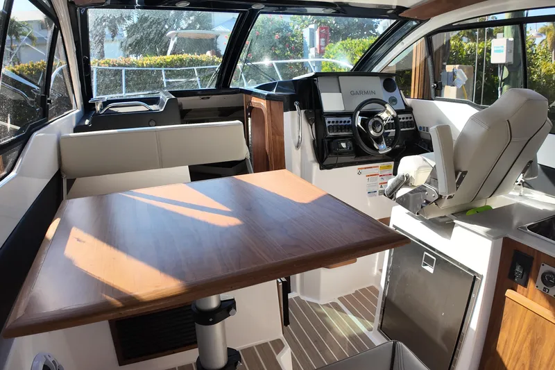  Yacht Photos Pics Interior of 2026 Solara S-250 Coupe boat with modern helm and wooden table.