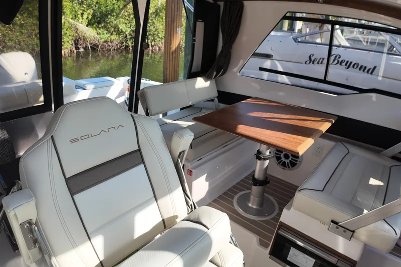  Yacht Photos Pics 2026 Solara S-250 Coupe interior with luxurious seating and wooden table.