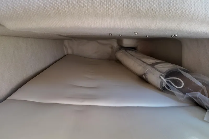  Yacht Photos Pics 2026 Solara S-250 Coupe interior storage compartment with rolled-up accessory.