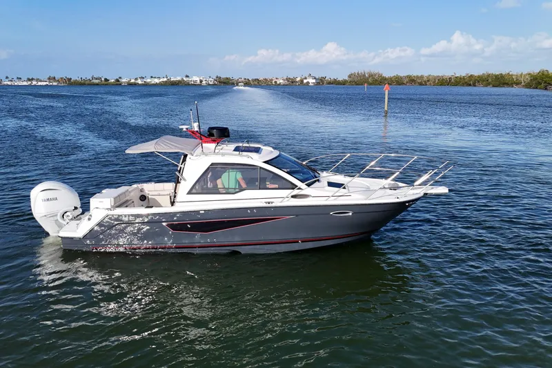 Yacht Photos Pics 2026 Solara S-250 Coupe boat cruising on a calm, scenic waterway.
