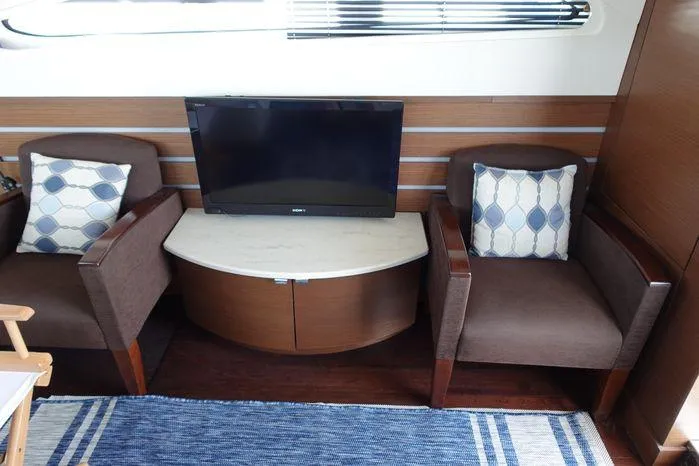  Yacht Photos Pics Interior of 2012 Sea Ray 450 Sedan Bridge with TV, chairs, and decorative pillows.