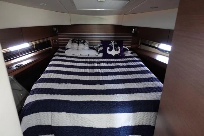  Yacht Photos Pics Luxurious bedroom in 2012 Sea Ray 450 Sedan Bridge with nautical-themed bedding.