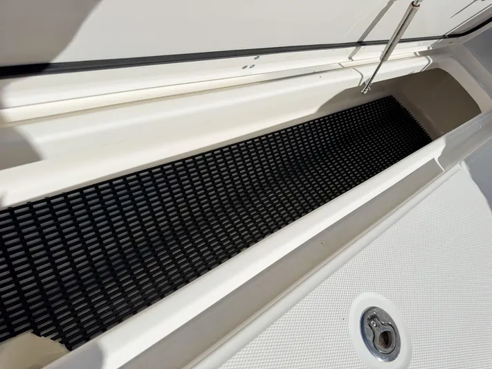 Crews Ship Yacht Photos Pics Boston Whaler 350 Outrage 2015 storage compartment with black mat and drain plug.