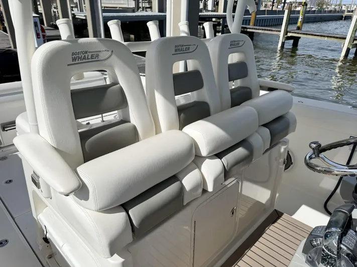 Crews Ship Yacht Photos Pics 2015 Boston Whaler 350 Outrage boat seats, white leather, docked by the water.
