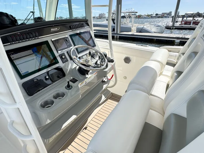 Crews Ship Yacht Photos Pics 2015 Boston Whaler 350 Outrage helm with modern controls and seating, docked at marina.