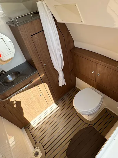 Crews Ship Yacht Photos Pics 2015 Boston Whaler 350 Outrage cabin bathroom with wood accents and modern fixtures.