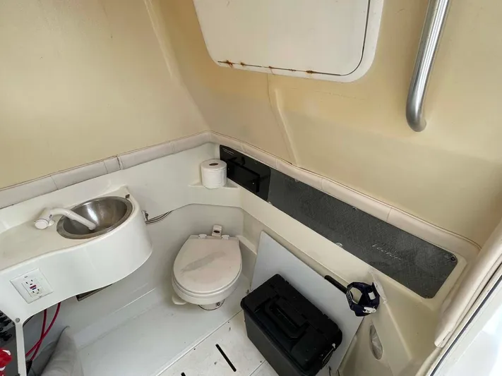 El Gringo Yacht Photos Pics 2004 Hydra-Sports 3300 CC boat interior with compact bathroom, featuring a toilet and sink.