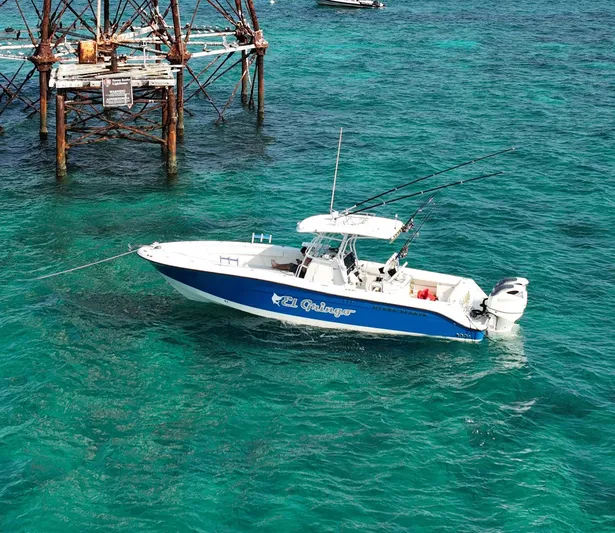 El Gringo Yacht Photos Pics 2004 Hydra-Sports 3300 CC boat anchored in clear turquoise water near a metal structure.
