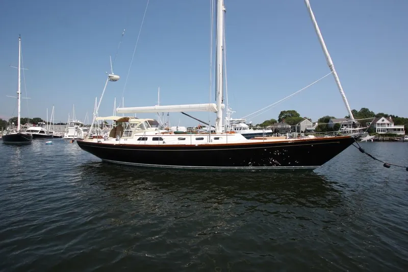 Regulus Yacht Photos Pics Hinckley Sou'wester 51 sailboat, 1993 model, anchored in a marina under clear blue skies.