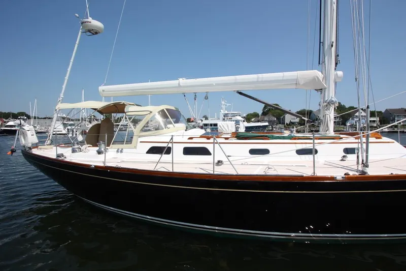 Regulus Yacht Photos Pics Hinckley Sou'wester 51 sailboat, 1993 model, docked in a marina under clear blue skies.