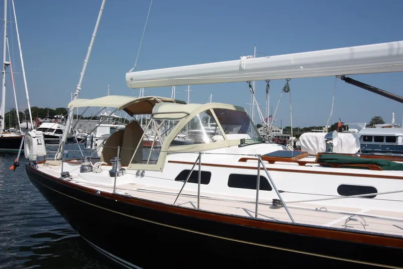 Regulus Yacht Photos Pics Hinckley Sou'wester 51 sailboat, 1993 model, docked in a marina under clear blue skies.