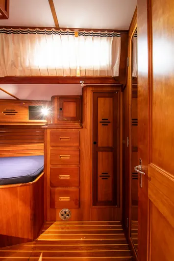 Regulus Yacht Photos Pics Interior of 1993 Hinckley Sou'wester 51 yacht, featuring wooden cabinetry and cozy sleeping area.