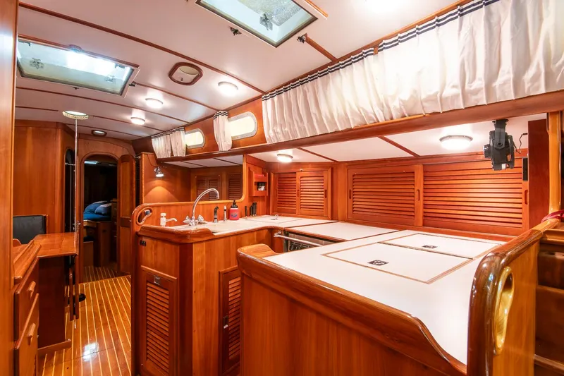 Regulus Yacht Photos Pics Luxurious wooden interior of 1993 Hinckley Sou'wester 51 yacht, featuring a well-equipped galley.