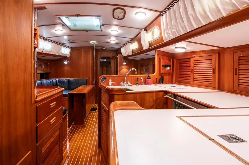 Regulus Yacht Photos Pics Luxurious interior of 1993 Hinckley Sou'wester 51 yacht with wooden cabinetry and modern amenities.