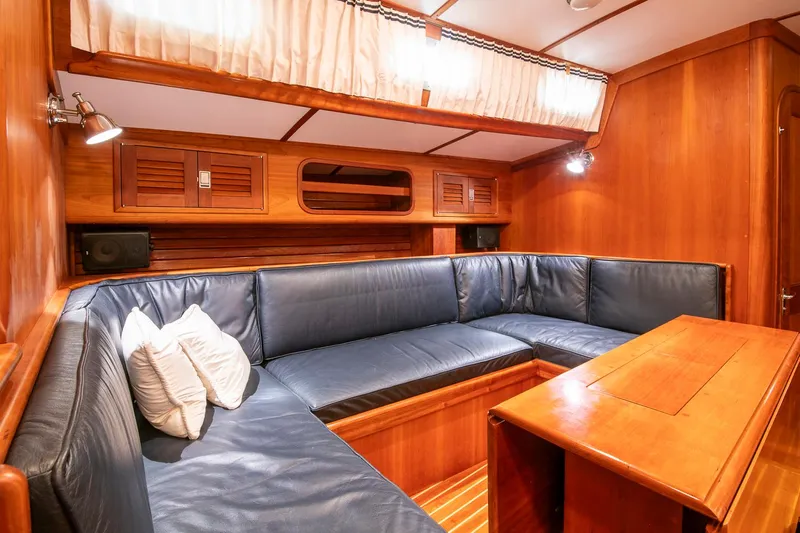 Regulus Yacht Photos Pics Luxurious wooden interior of 1993 Hinckley Sou'wester 51 yacht with blue leather seating.