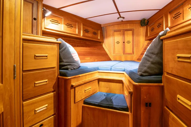Regulus Yacht Photos Pics Cozy wooden cabin interior of 1993 Hinckley Sou'wester 51 sailboat with blue cushions.