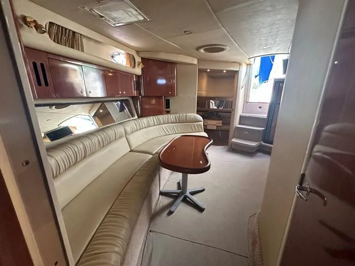  Yacht Photos Pics Luxurious interior of 2000 Sea Ray 410 Sundancer yacht with plush seating and wooden table.