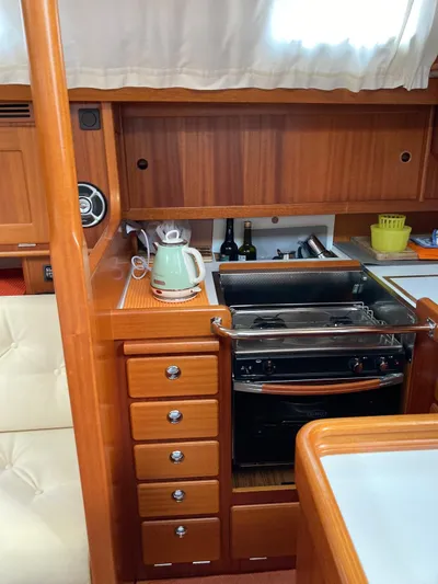 Morgan's Moon Yacht Photos Pics Hallberg-Rassy 43 yacht kitchen interior with stove, kettle, and wooden cabinetry, 2008 model.