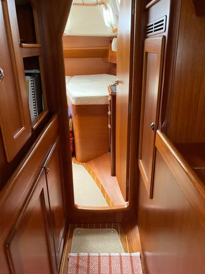 Morgan's Moon Yacht Photos Pics Interior of 2008 Hallberg-Rassy 43 sailboat, featuring wooden cabinetry and cozy sleeping quarters.