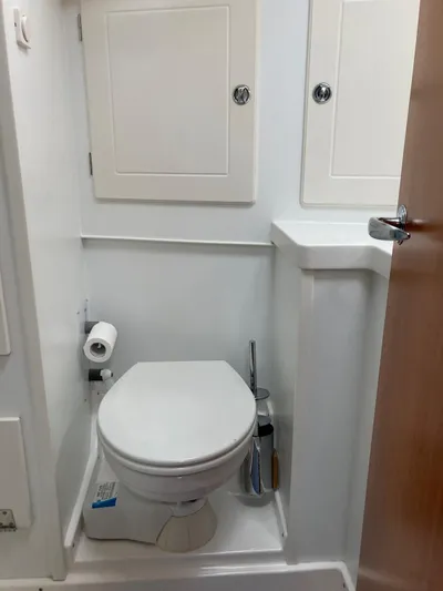 Morgan's Moon Yacht Photos Pics 2008 Hallberg-Rassy 43 yacht bathroom with toilet, storage cabinets, and toilet paper holder.
