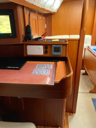 Morgan's Moon Yacht Photos Pics Interior of 2008 Hallberg-Rassy 43 yacht with navigation station and wooden finish.
